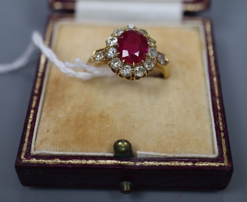 An early 20th century 18ct gold, synthetic? ruby and old round cut diamond set oval cluster ring, size N, gross 5 grams.